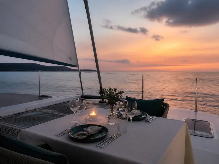Private dinner table aboard a catamaran at Caribbean sunset